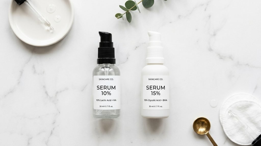 Two minimalist skincare tubes displaying different concentration percentages on marble